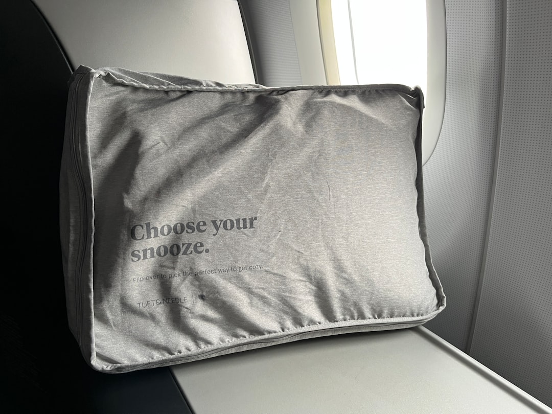 飛行機にあると便利な女性向けグッズを足元の透明ポーチに整理した機内のイメージ