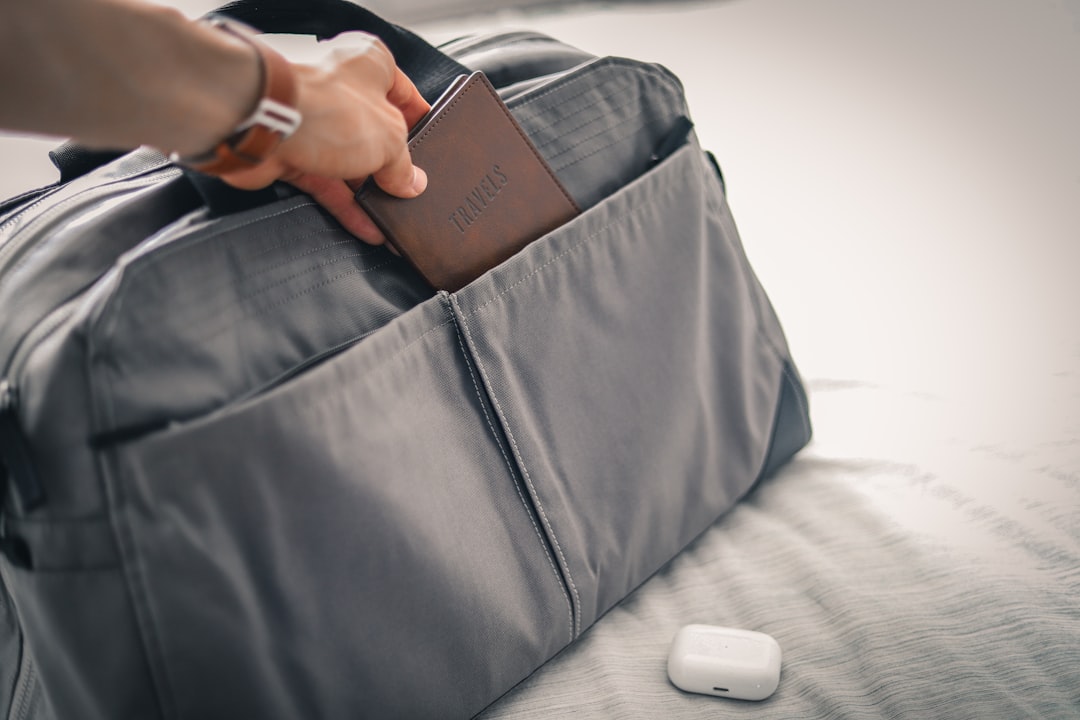 旅行用のモバイルバッテリーをバッグに入れて空港を歩く旅行者